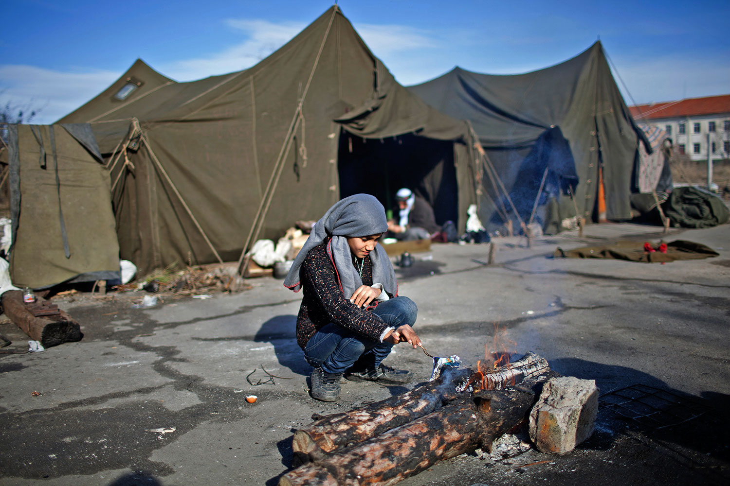 Fent: szír lány éleszti a tüzet a bulgáriai Harmanliban lévő menekülttáborban Pierre Marsaut / Reuters